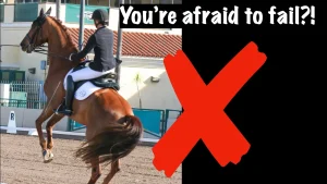 A person in equestrian attire rides a horse rearing up, with a building and arena in the background. Large white text reads “You’re afraid to fail?!”—highlighting fear of failure—with a bold red “X” beside the rider.