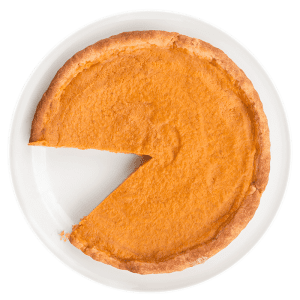A round sweet potato pie with a golden-brown crust sits on a white plate. One large slice has been removed, revealing the smooth orange filling.