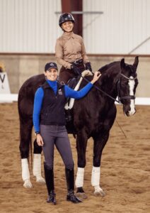 Amelia and 55+ rider stand and smile at the camera